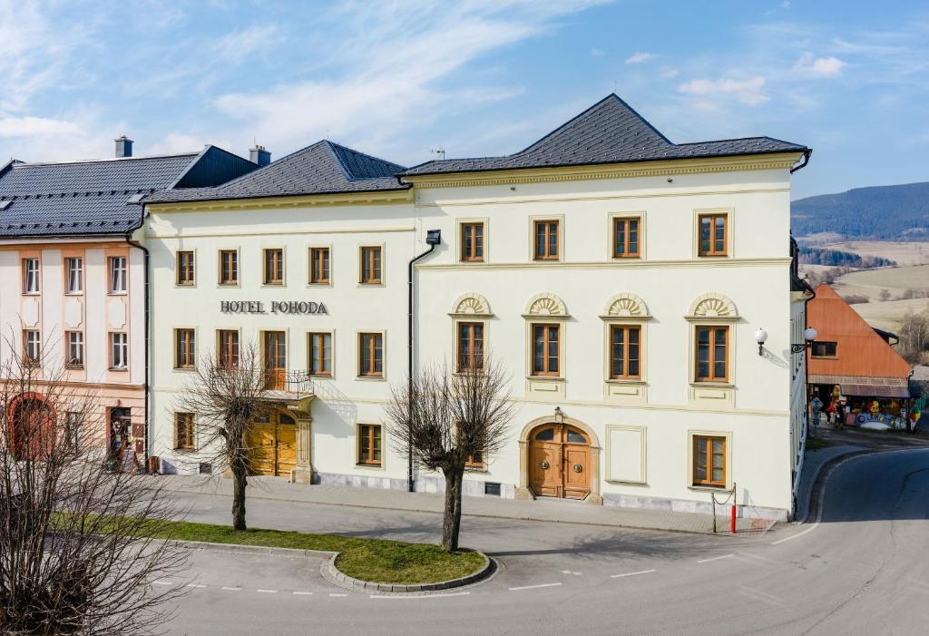a large white building on the side of a street at Hotel Pohoda in Staré Město