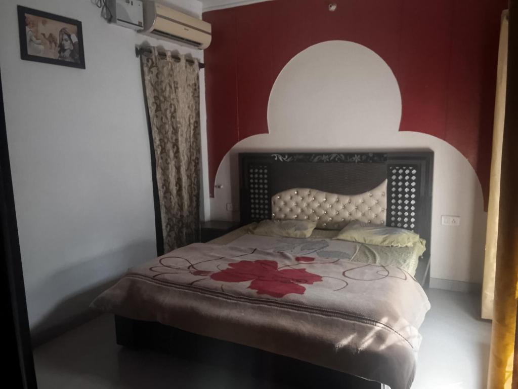 a bedroom with a bed in a red wall at Shiva House in Dehradun