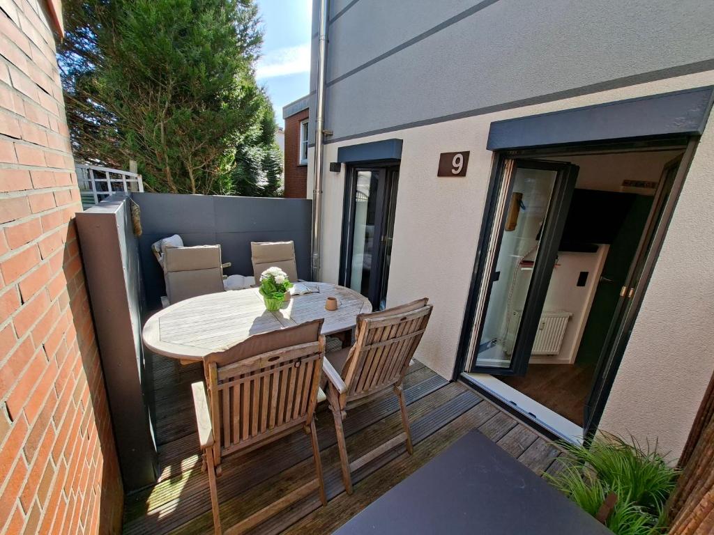 a patio with a table and chairs on a balcony at Lachmöwe by DeJu -4 Sterne DTV-Klassifizierung- in Norderney