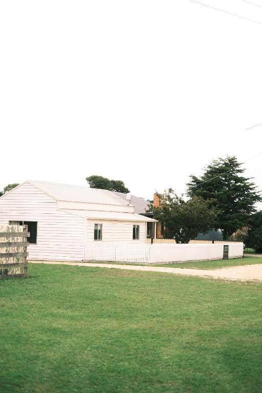 a white barn with a fence in a yard at Longford Cottage in Longford