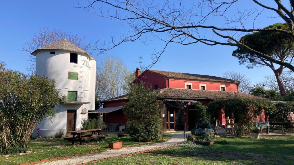 a building with a silo next to a house at Agriturismo Case Mori in Rimini