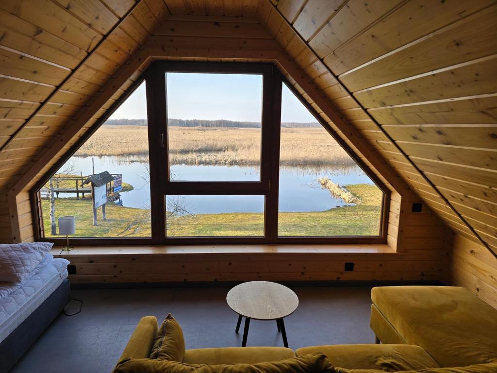 a living room with a large window in a cabin at Dolina Biebrzy - Chata Flisaka in Wroceń
