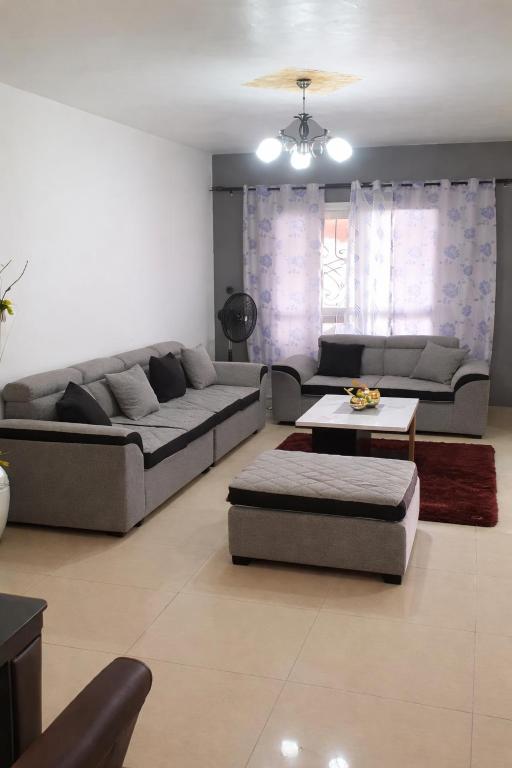 a living room with a couch and a table at Makepe Bungalow Style in Douala