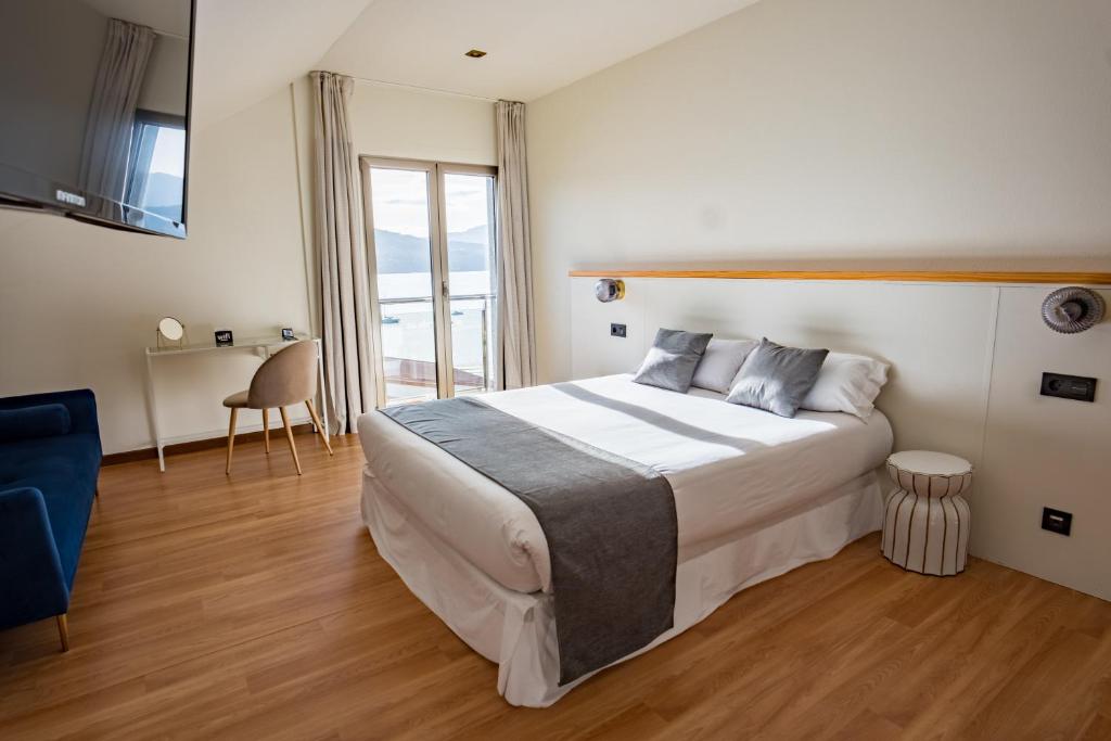 a bedroom with a large bed and a large window at Alda Corcubión in Corcubión