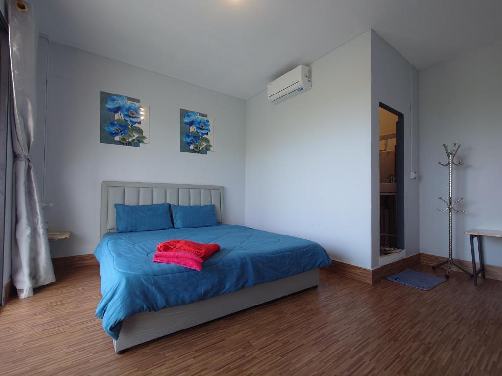 a bedroom with a blue bed with a red blanket at New Land Hostel in Kaôh Rŭng (3)