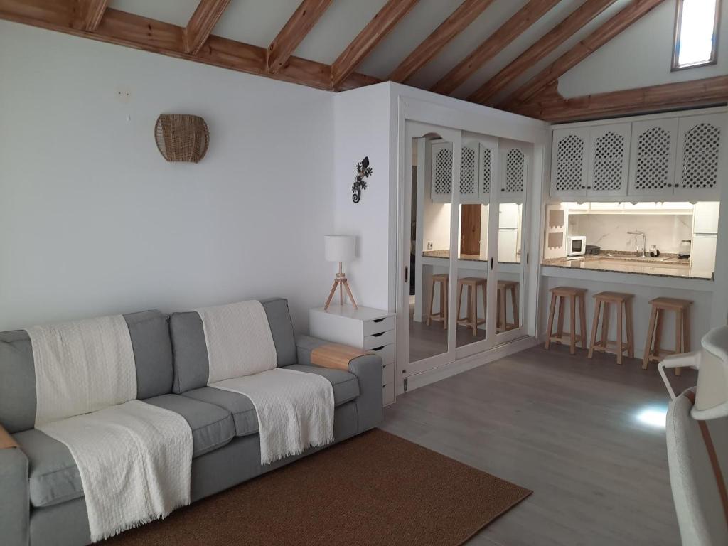 a living room with a couch and a kitchen at Casas Lapa in Costa Teguise