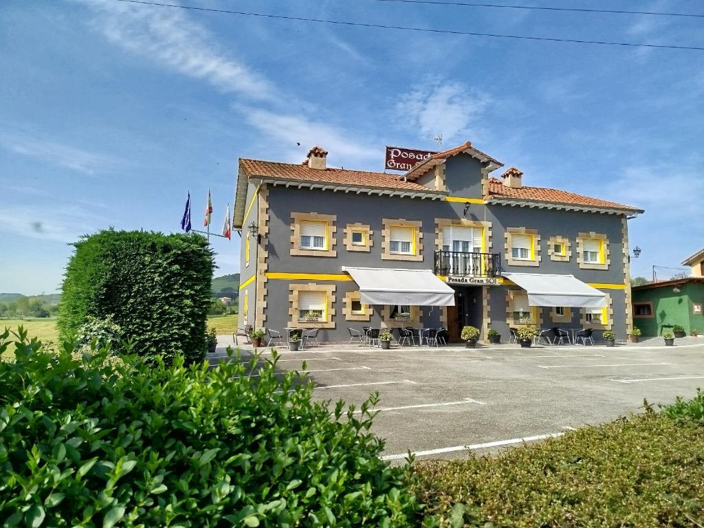 a large yellow building with tables and chairs in a parking lot at Posada Gran Sol in Queveda