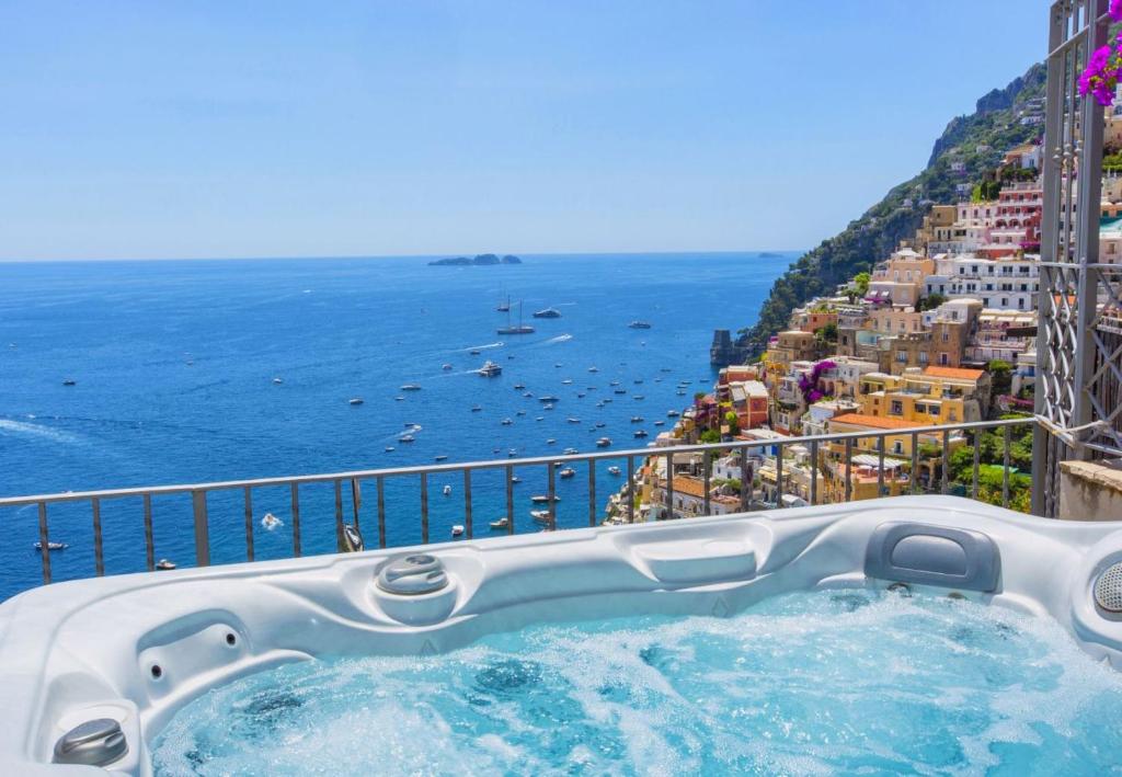 a hot tub on a balcony overlooking the ocean at Hotiday Positano Volte Alte in Positano