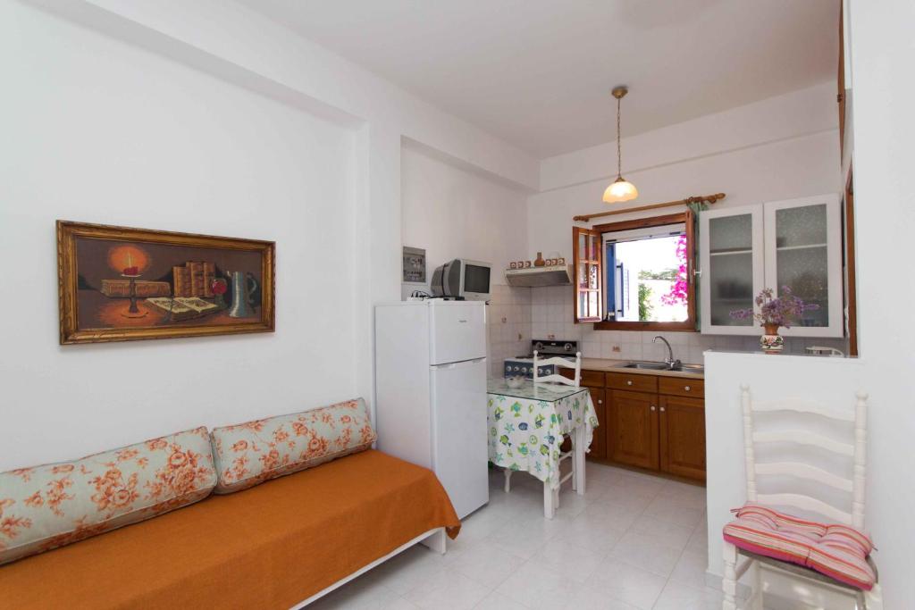 a living room with a couch and a kitchen at Cycladic Grandma's Apartments in Parikia