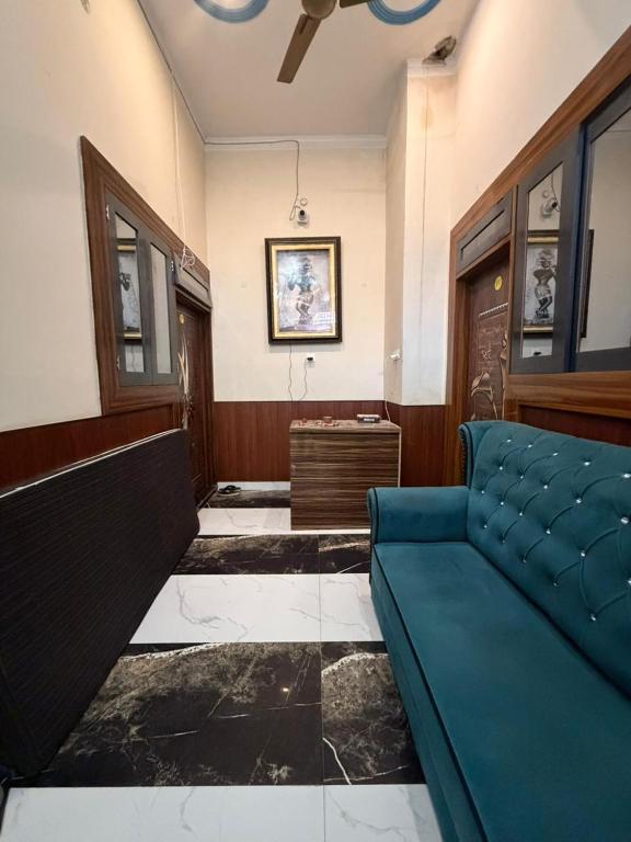 a living room with a blue couch in a room at Nisha sadan in Vrindāvan
