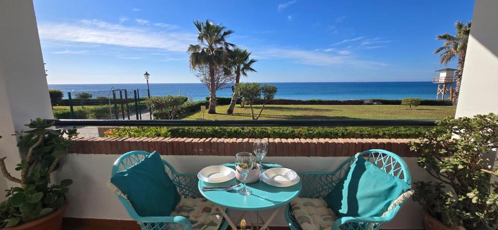 a table and chairs on a balcony with a view of the ocean at Peñoncillo Beach in Torrox Costa