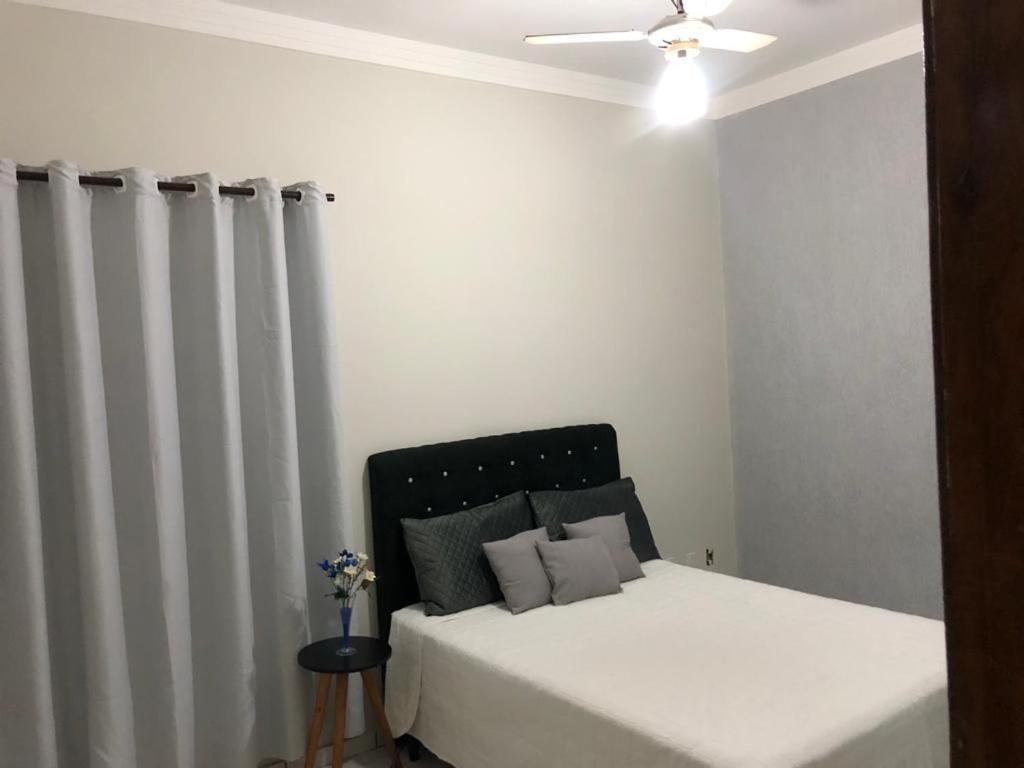 a bedroom with a white bed and a radiator at Casa nova 2 quartos in Montes Claros