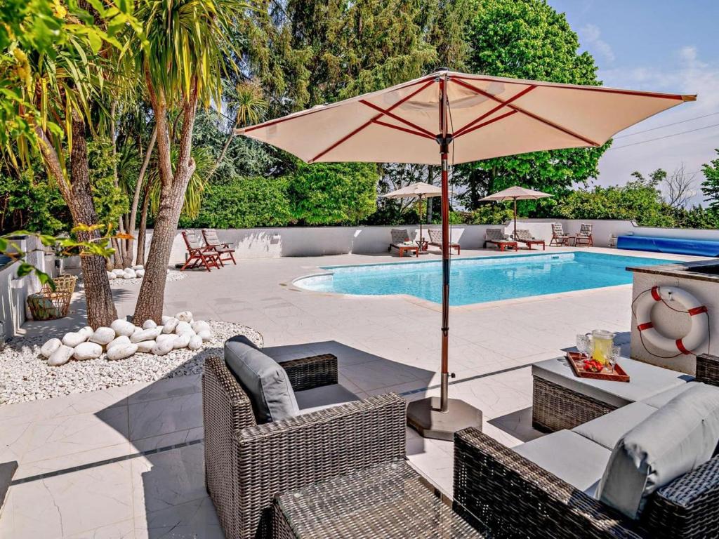 a patio with an umbrella and chairs and a pool at 2 Bed in Minehead oc-90925 in Minehead