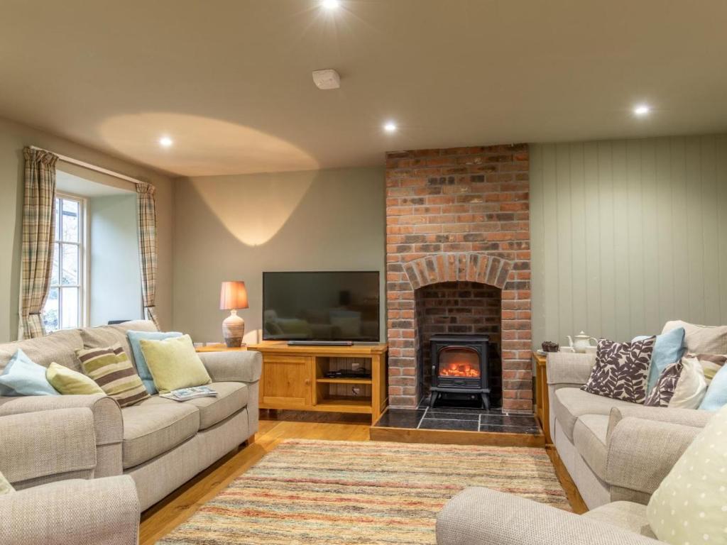 a living room with two couches and a fireplace at 3 Bed in Axminster oc-bloco in Axminster