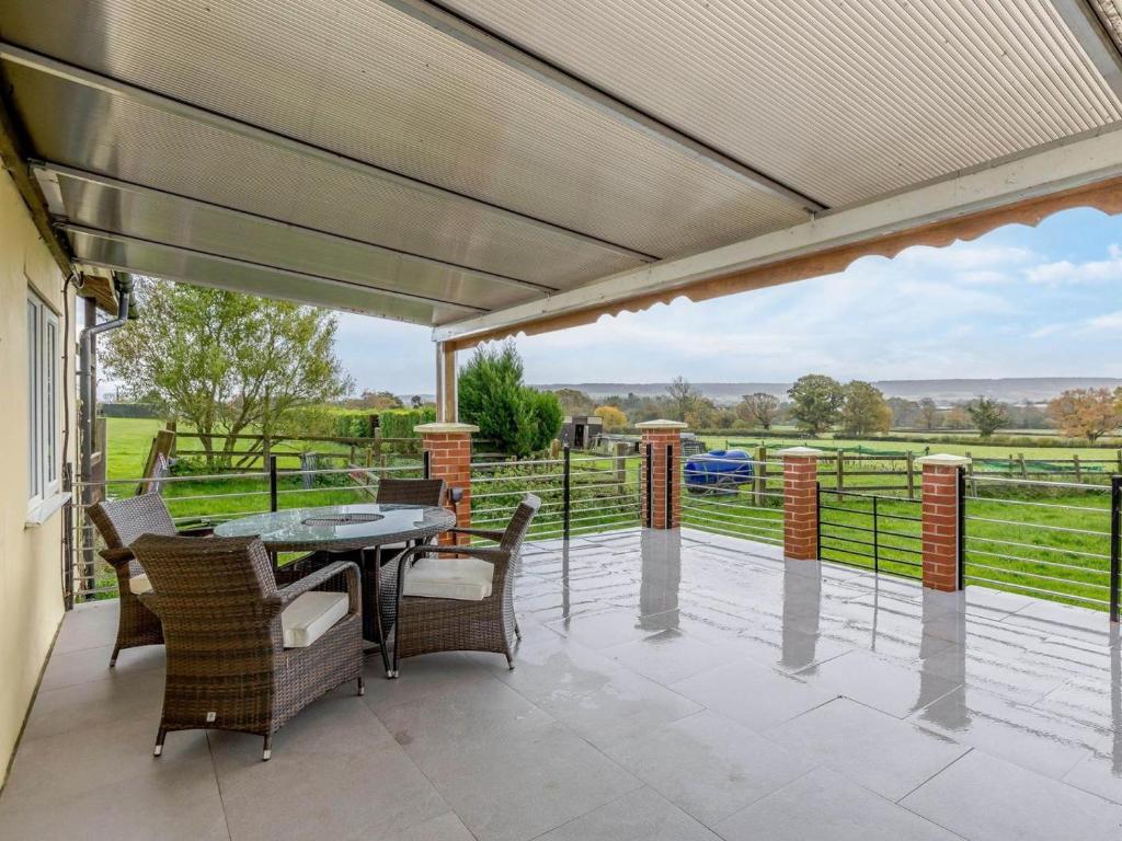 a patio with a table and chairs and a view of a field at 2 Bed in Ottery St Mary oc-lambs in Ottery Saint Mary