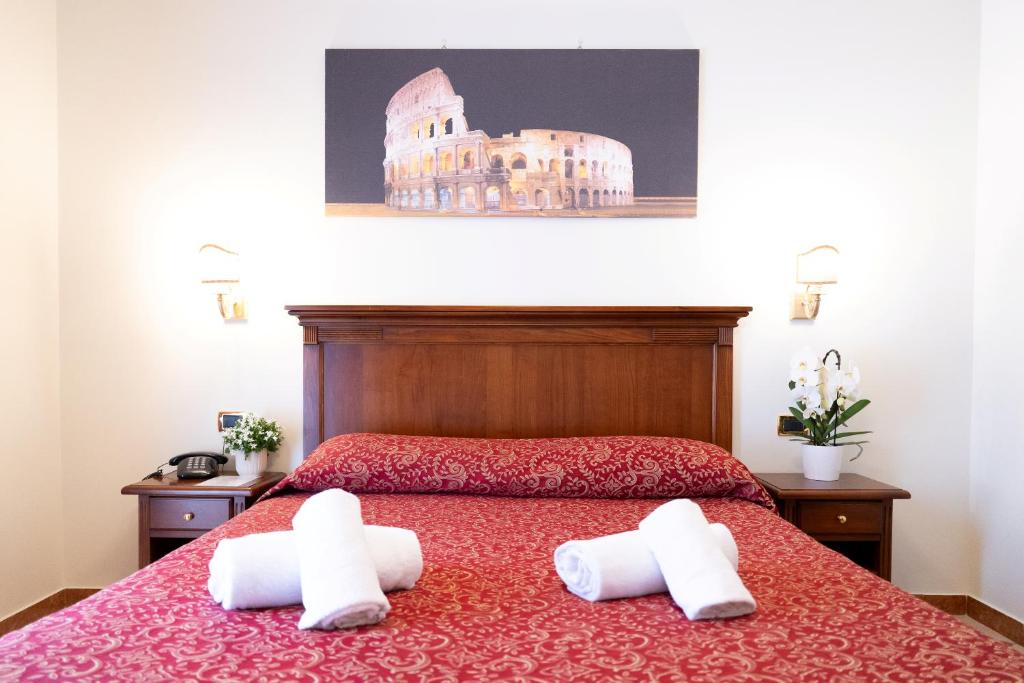 a bedroom with a bed with two towels on it at Hotel RomAntica in Rome