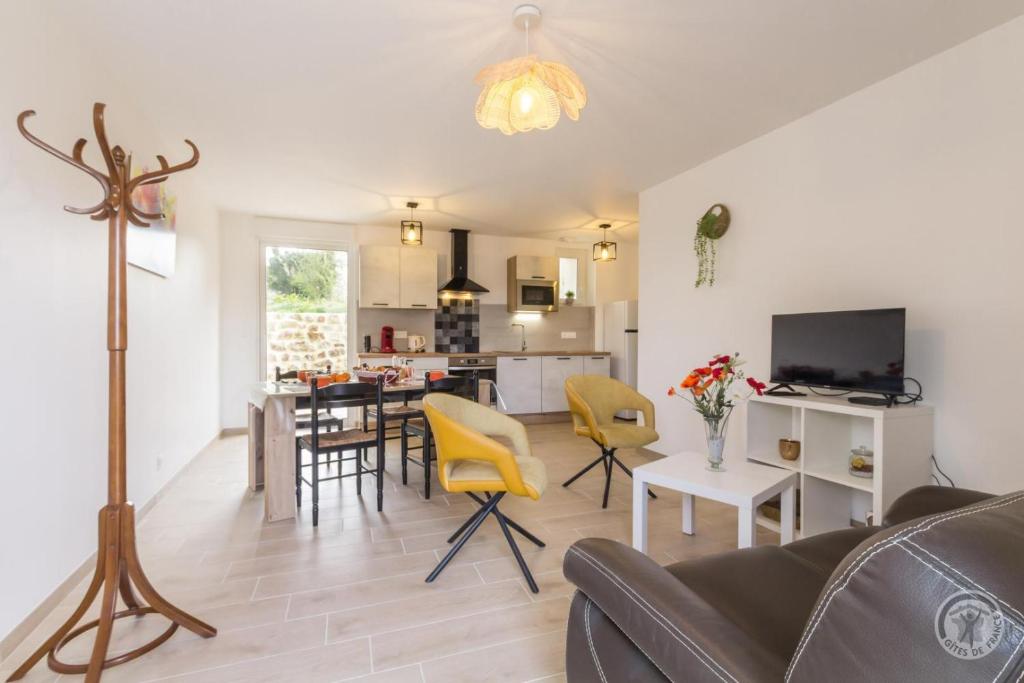 a living room with a couch and a table with yellow chairs at Gîte G1304 in Sottevast
