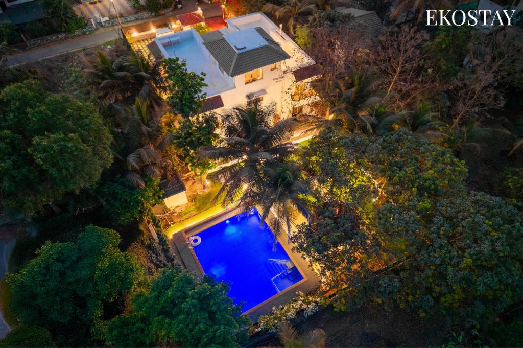 an overhead view of a swimming pool in front of a house at EKOSTAY Gold - Amara Villa in Alibaug