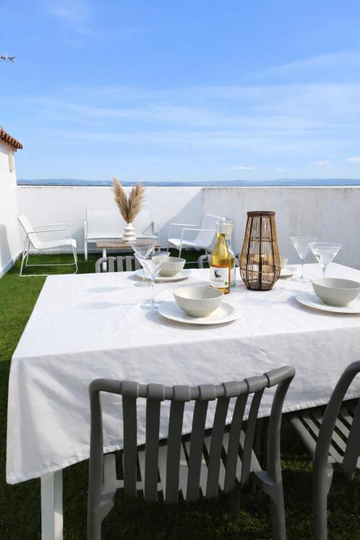 a table with a white tablecloth and chairs and the ocean at La Pau Apartament in Mollerussa