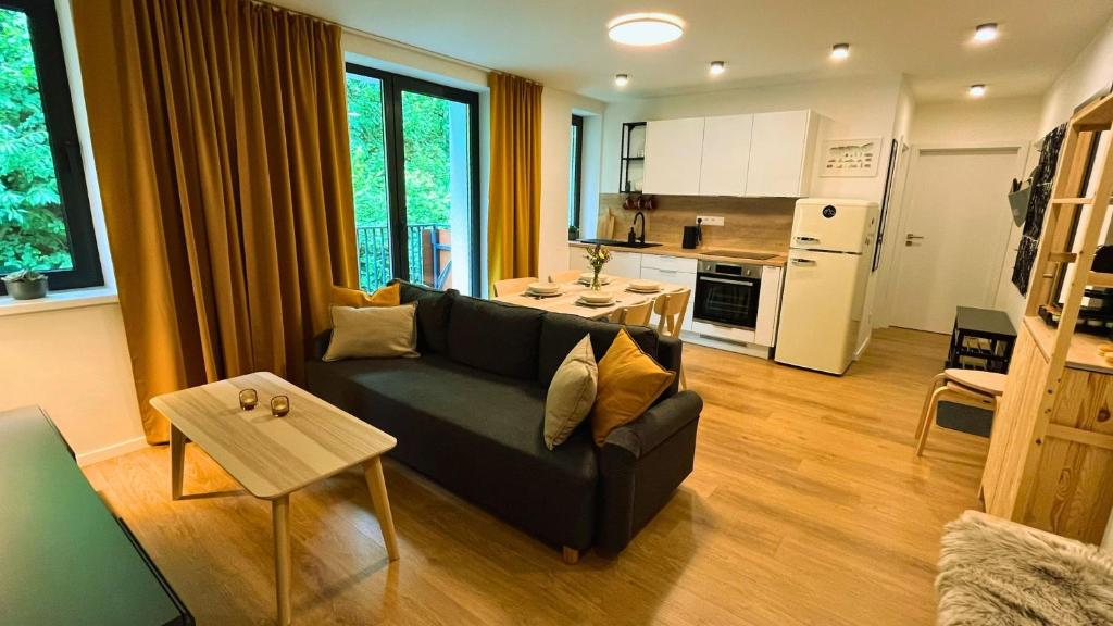 a living room with a couch and a kitchen at Adventourist - Apartmán Terchová in Terchová