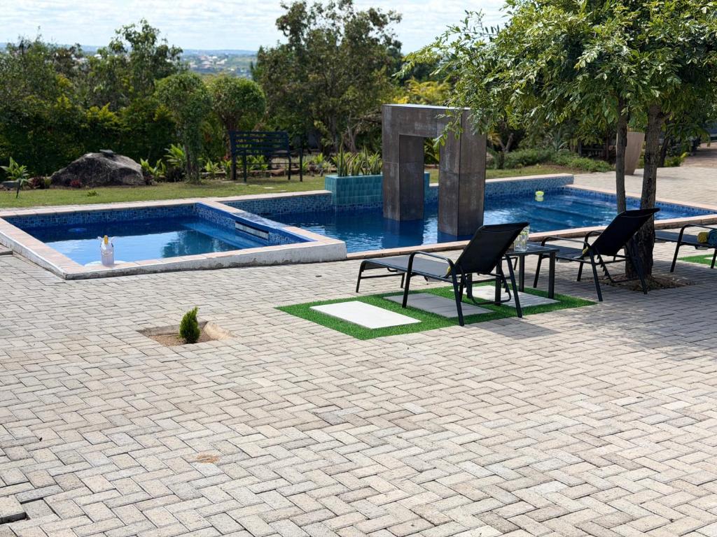 a patio with two chairs and a swimming pool at Yandheya Guest House in Calcutta