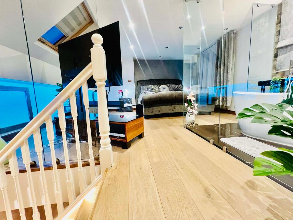 a room with a staircase and a bathroom with a tub at Arnie in Longley