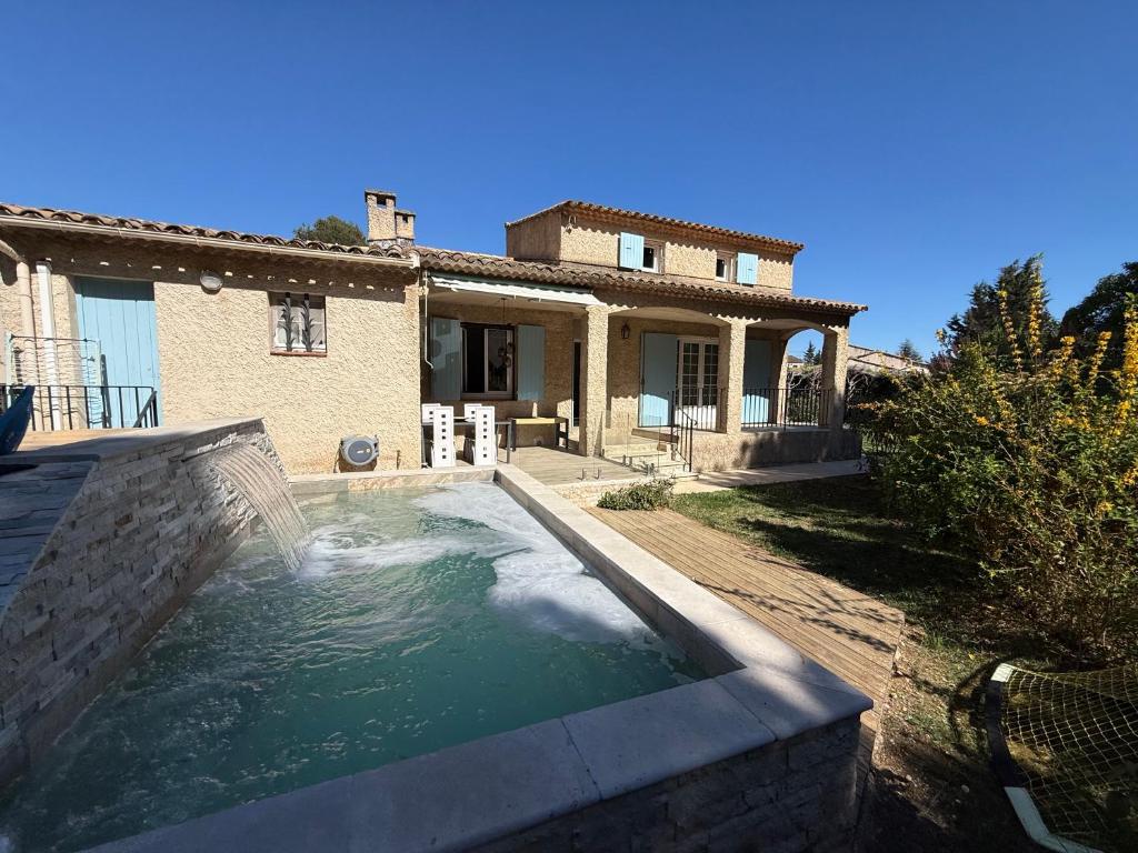 a swimming pool in front of a house at La Laurisienne in Lauris