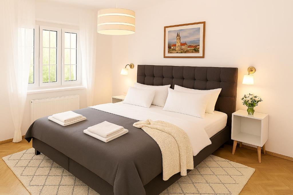 a bedroom with a large bed with two towels on it at Deluxe Apartments Zagreb in Zagreb