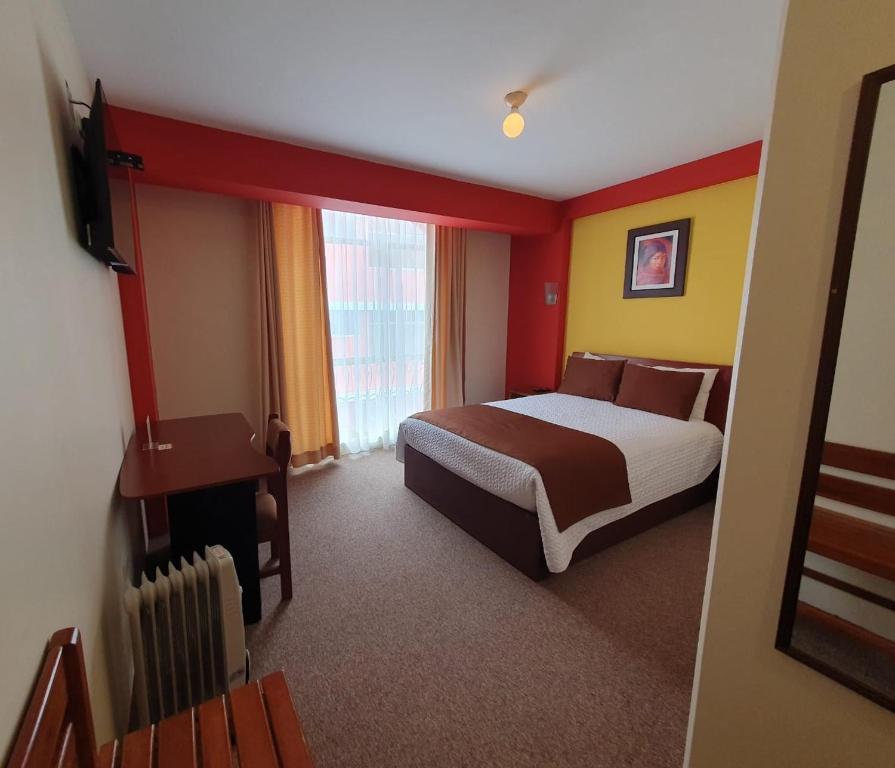 a hotel room with a bed and a window at Hotel Munay Tambo in Puno