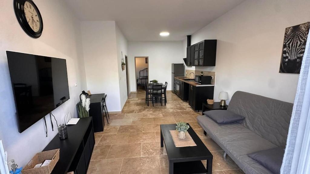 a living room with a couch and a table at Maison T2 avec terrasse et cours de 50m2 in Sorgues