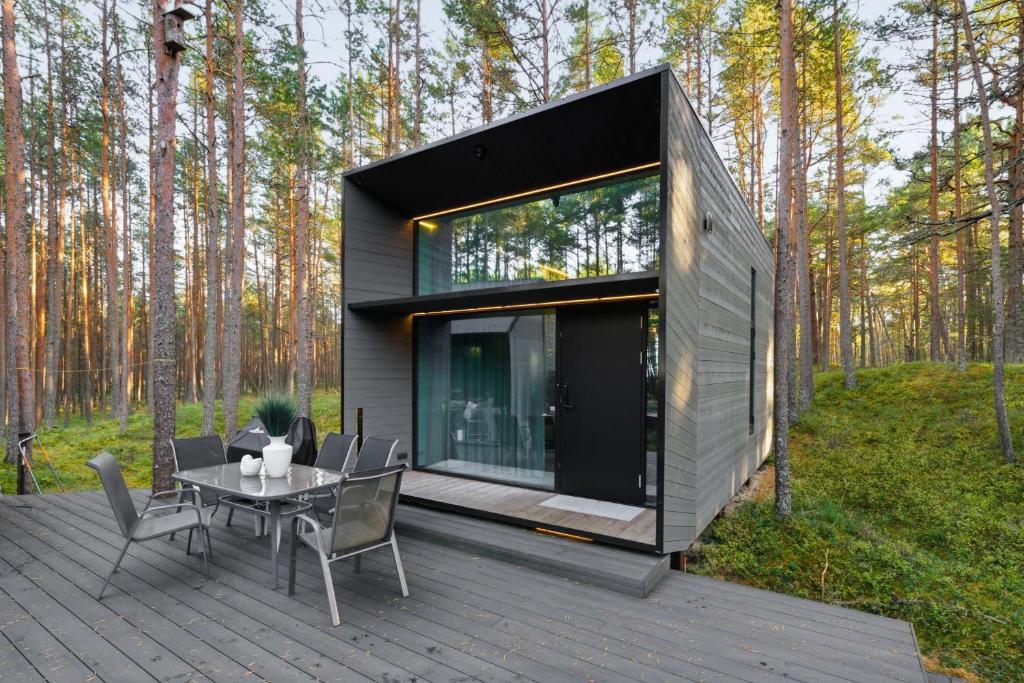 a house with a table and chairs on a deck at Relax al Mare with sauna near the sea in Laulasmaa