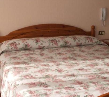 una camera da letto con un letto con copriletto floreale di Due Mori a Roana