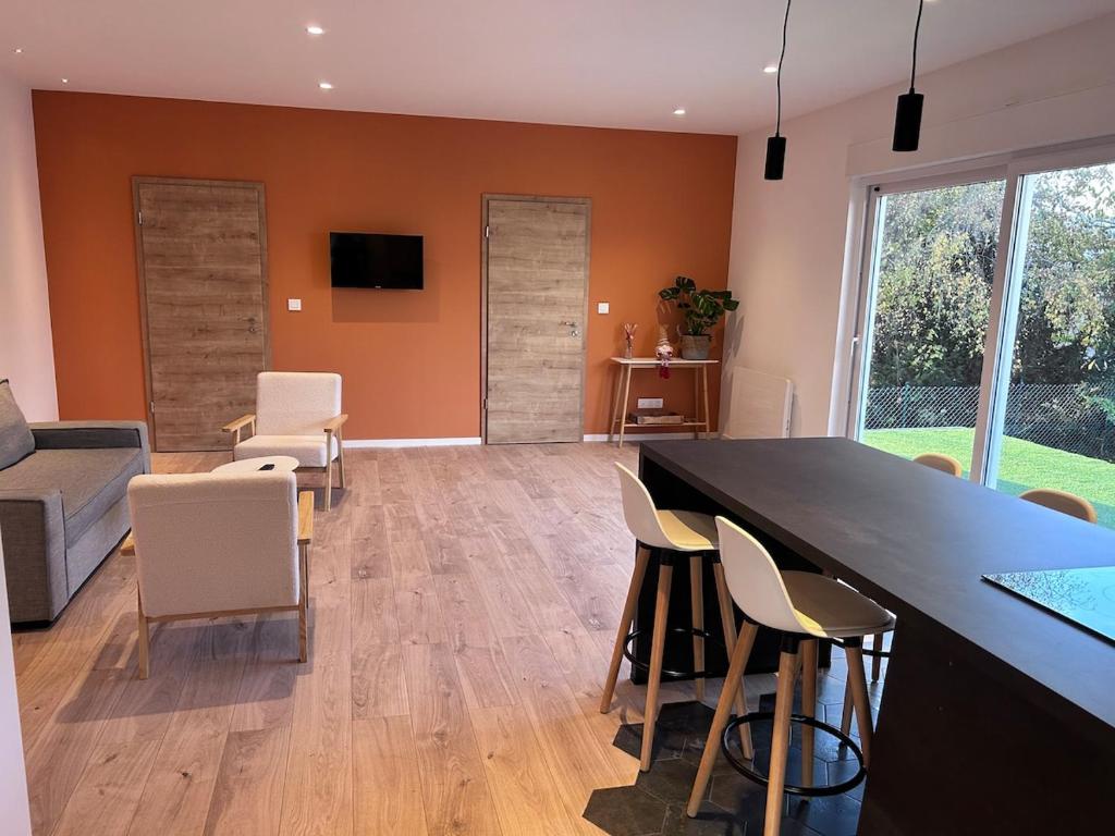 a living room with a large black table and chairs at Appartement proche de Colmar in Horbourg