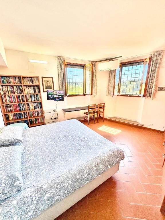 a bedroom with a bed and a desk with chairs at Villetta Gabriella in Impruneta
