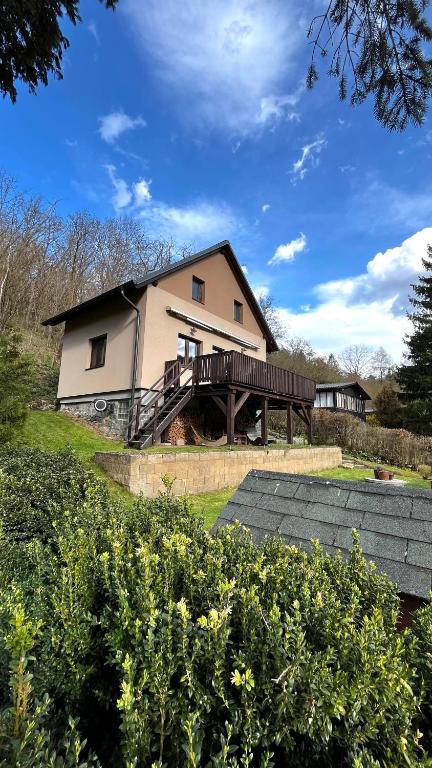 a house with a wooden deck in front of it at Chata u Studnaře in Křivoklát