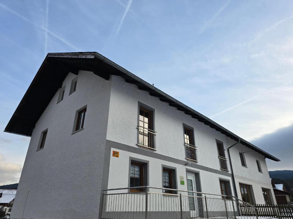 a large white building with a black roof at Ferienwohnung Wilde Hilde inklusive aktivCARD in Arrach