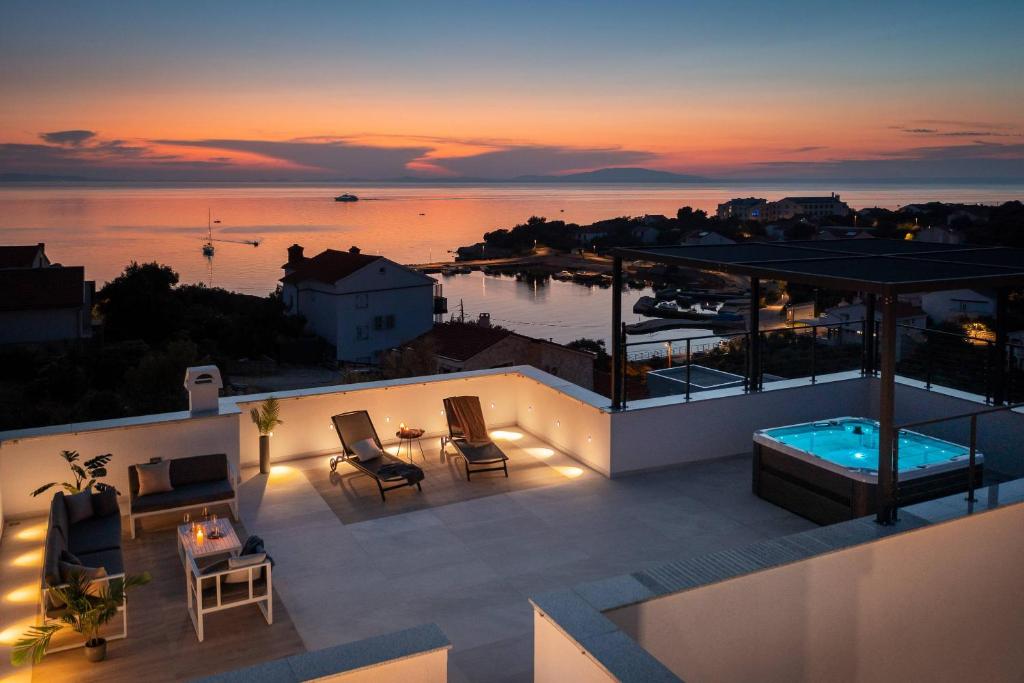 a rooftop deck with a view of the ocean at sunset at Villa Aria in Novalja