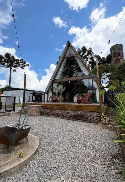 a small house with a glass window in a yard at Hospedagem de Charme Te Amo in Canela