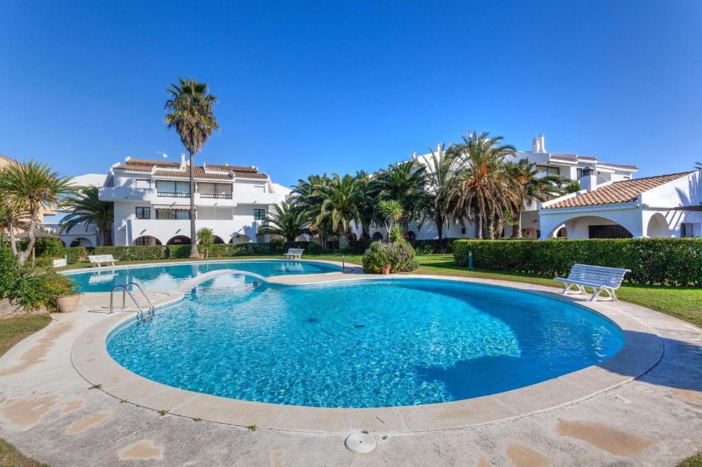 a swimming pool in front of a house with palm trees at Ducado B104 in Pals