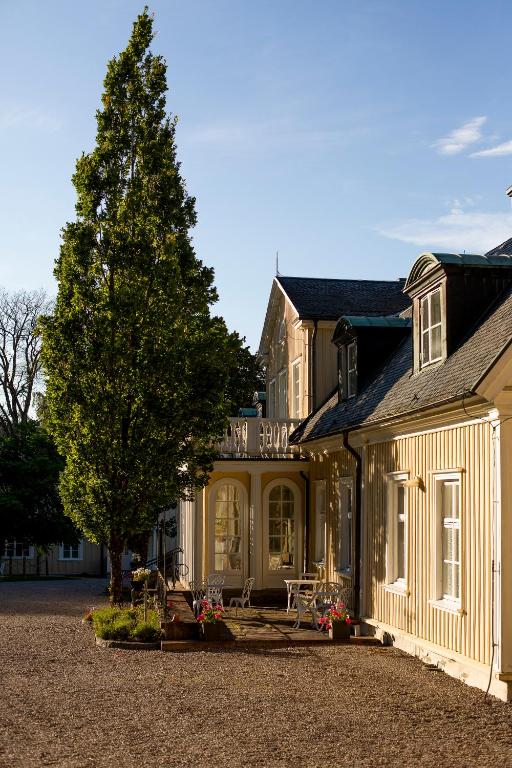 a large house with a tree in front of it at Munkedals Herrgård in Munkedal
