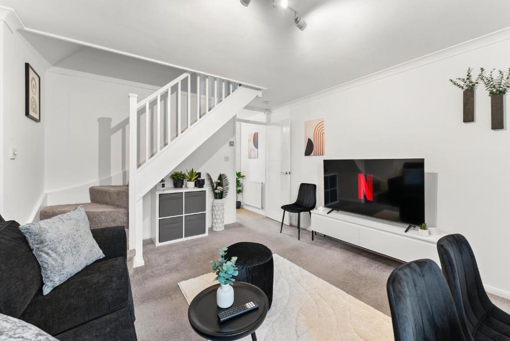 a living room with a couch and a tv at The Derby Escape - Garden -Sleeps 6 in Derby