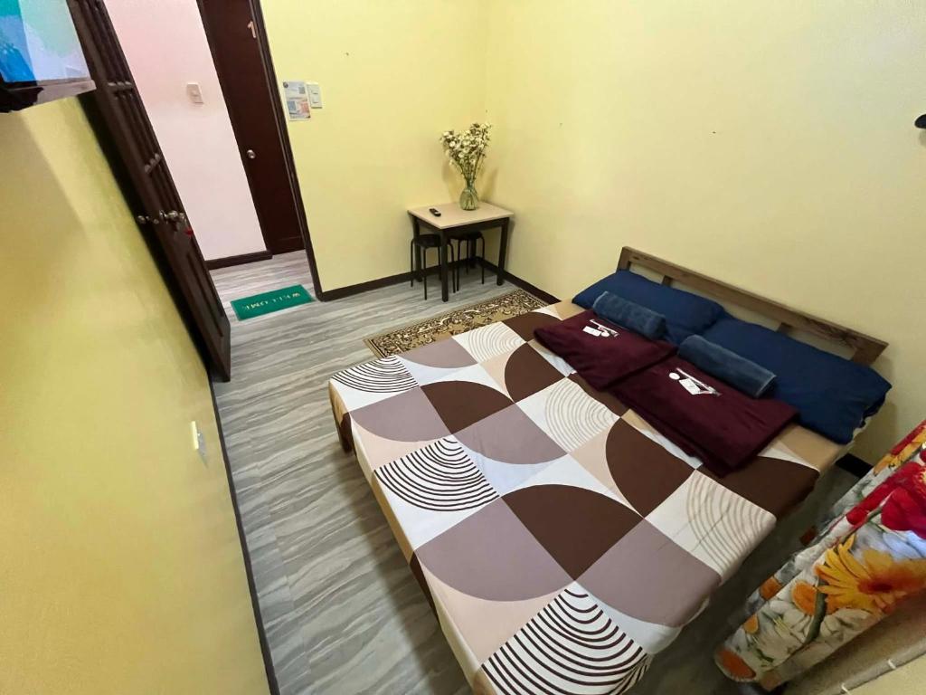 a bedroom with a bed and a table in it at Tipid Camp Baguio A2,A3,A7,A8 in Baguio