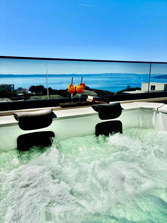 a boat in a body of water with waves at Penthouse Jacuzzi SeaView Suite in Makarska