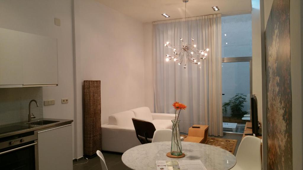 una cocina y una sala de estar con una mesa con un jarrón. en Loft designed City Center, en Toledo