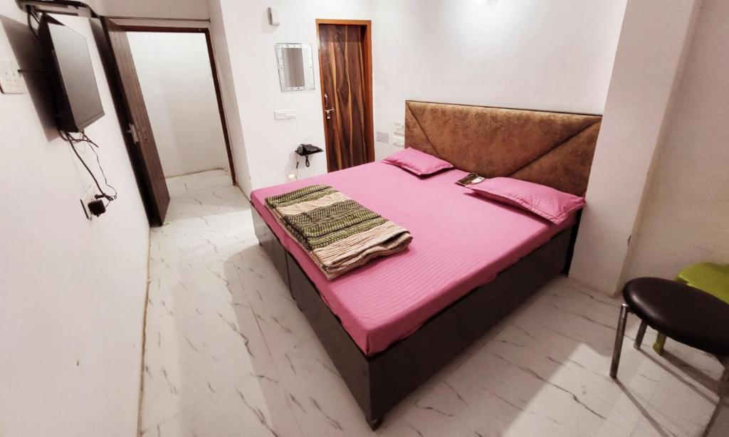 a small bedroom with a pink bed in a room at Hotel JK in Hanumāngarh