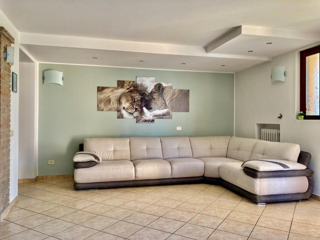 ein Wohnzimmer mit einer Couch und zwei Gemälden an der Wand in der Unterkunft Milele B&B in Somma Lombardo