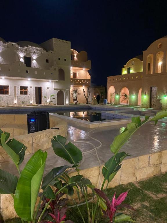 a resort with a swimming pool at night at Heaven Gates Hotel in Siwa