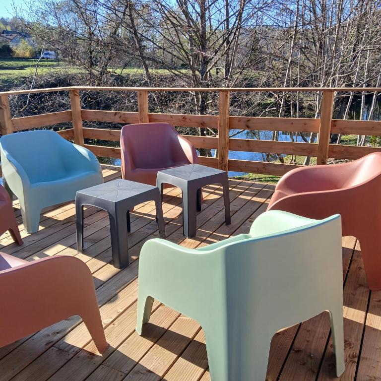 a deck with chairs and tables on a wooden deck at La D'homette in Fresse-sur-Moselle
