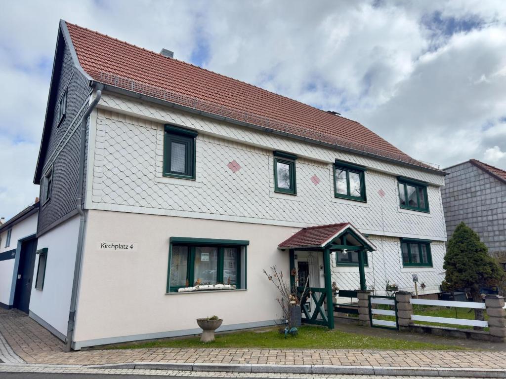 a white house with a red roof at Ferienwohnung Christina in Friedrichroda in Friedrichroda