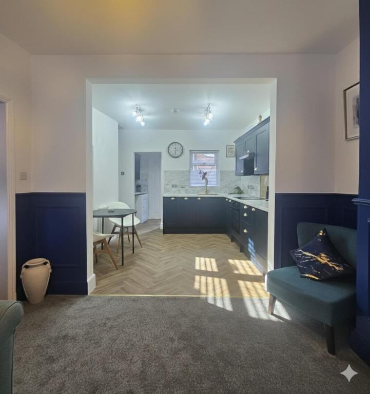 a living room with a table and a kitchen at The Quay Corner in Saint Thomas Station